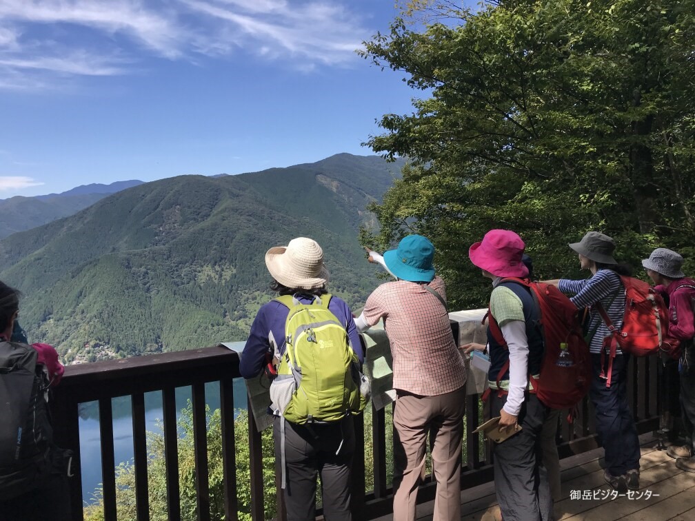 御前山から湖を眺める登山者